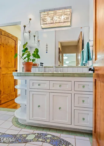 a kitchen with white cabinets and sink