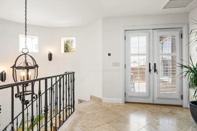 a view of a hallway with windows and a livingroom