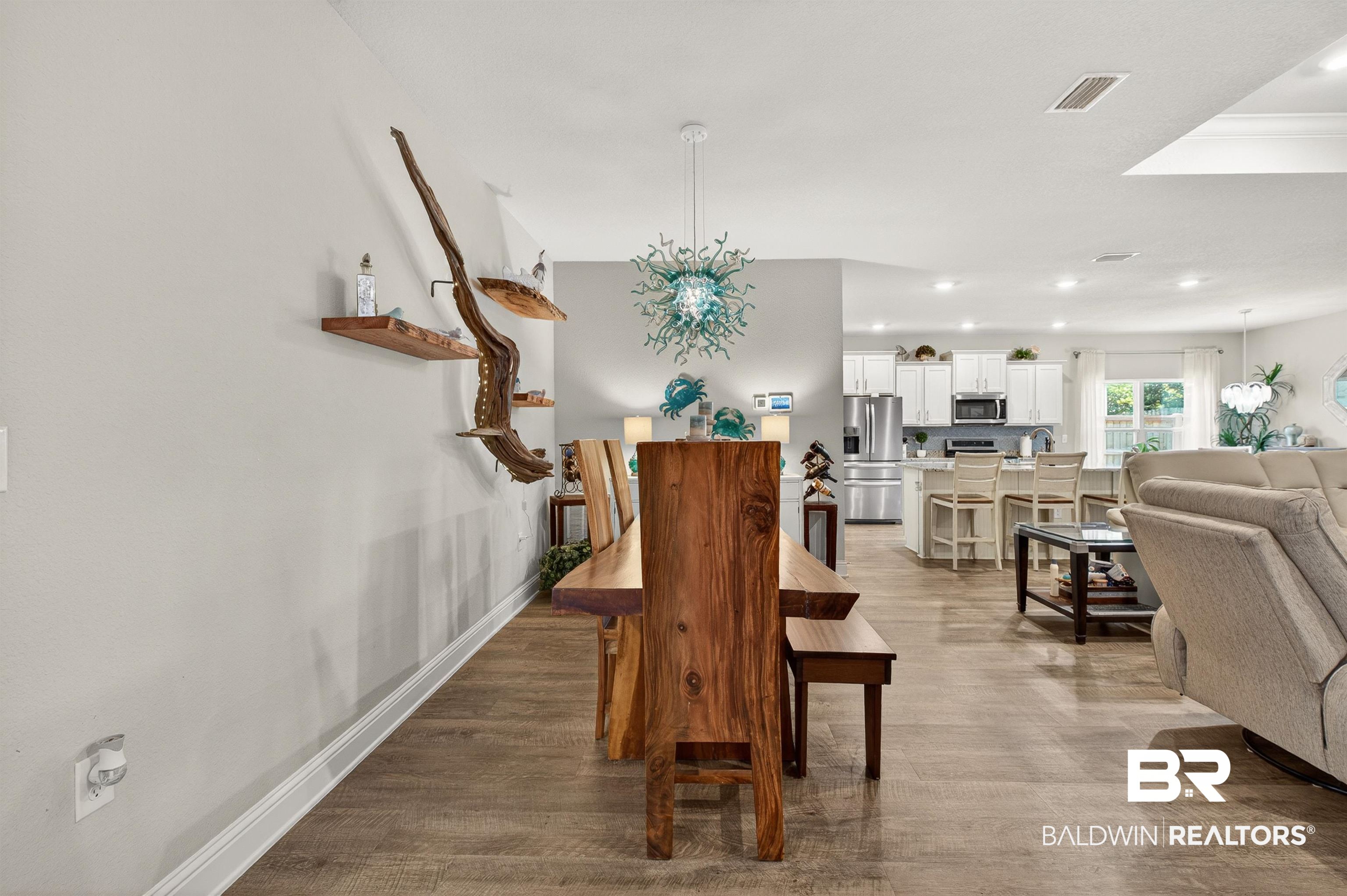 8735 Bronze Lane Foley, AL 36535 - Photo 18 of 58 Expansive open-concept living area featuring wood-finish flooring, a contemporary overhead light fixture, recessed ceiling lights, a white trim baseboard, and a neutral wall color