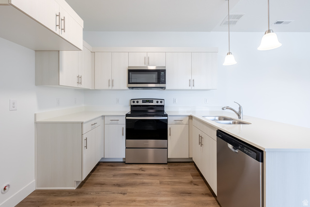 675 West 4500th South, Unit P301 Mapleton, UT 84664 - Photo 11 of 16 Contemporary kitchen featuring white cabinetry, light countertops, stainless steel appliances, and wood-finish flooring
