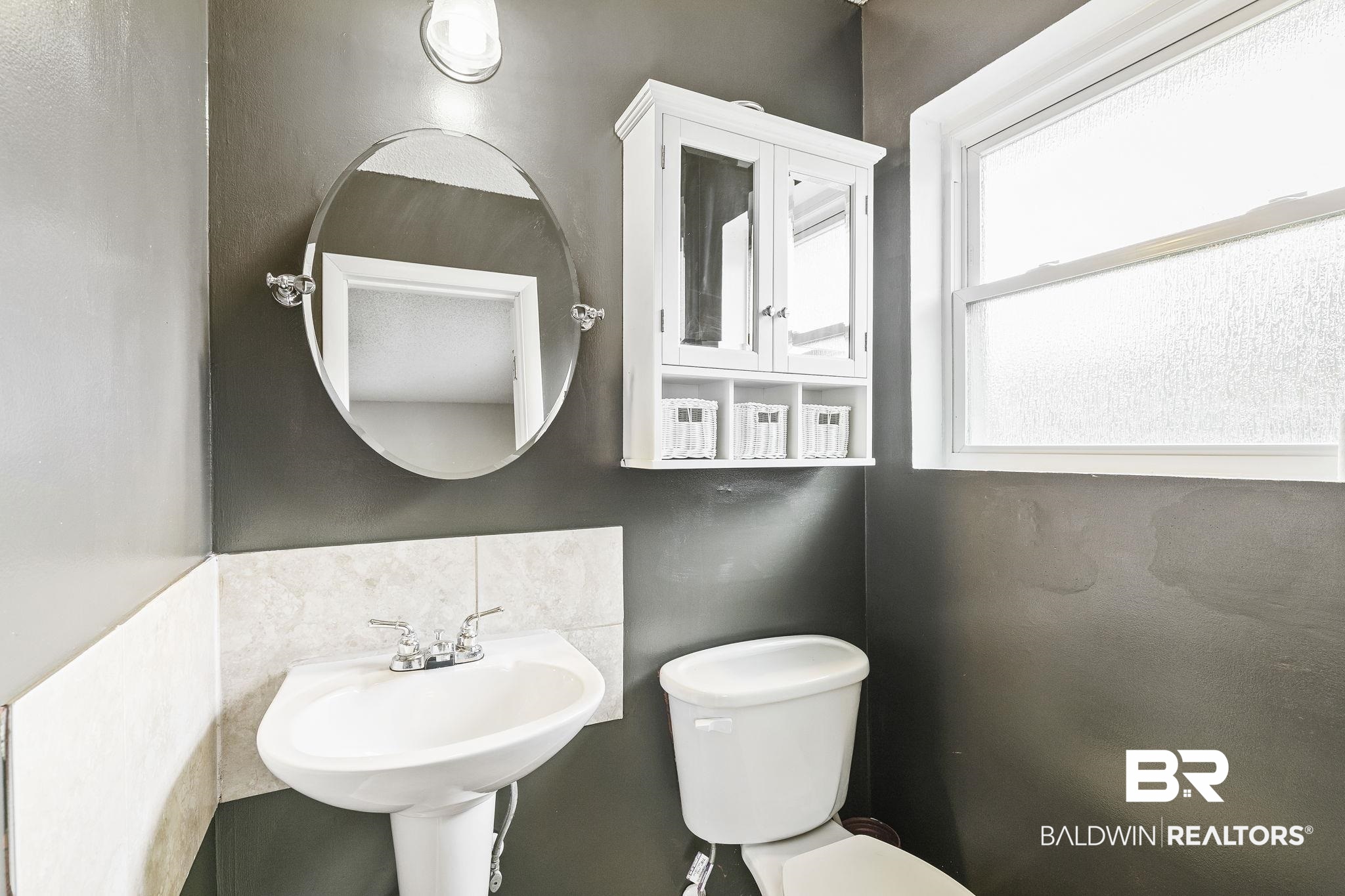 13108 6th Street Lillian, AL 36549 - Photo 26 of 39 Bathroom featuring tile walls, sink, toilet, and a healthy amount of sunlight