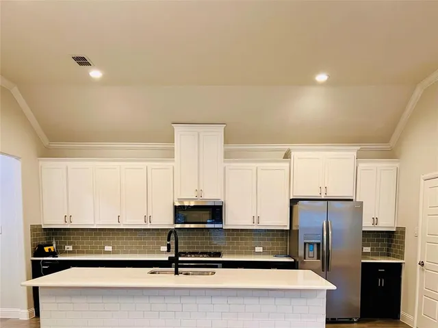 a view of kitchen with stainless steel appliances cabinets and a window