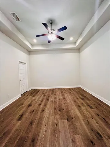 a view of empty room with wooden floor