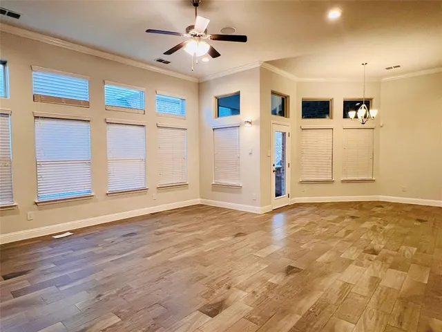 a view of a livingroom with wooden floor and a ceiling fan window