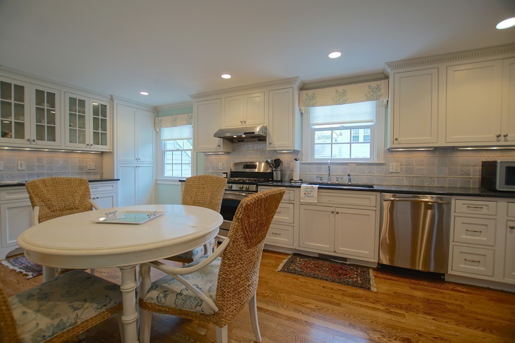 11 Shetland Road Marblehead, MA 01945 - Photo 15 of 28 a kitchen with granite countertop white cabinets appliances dining table and chairs