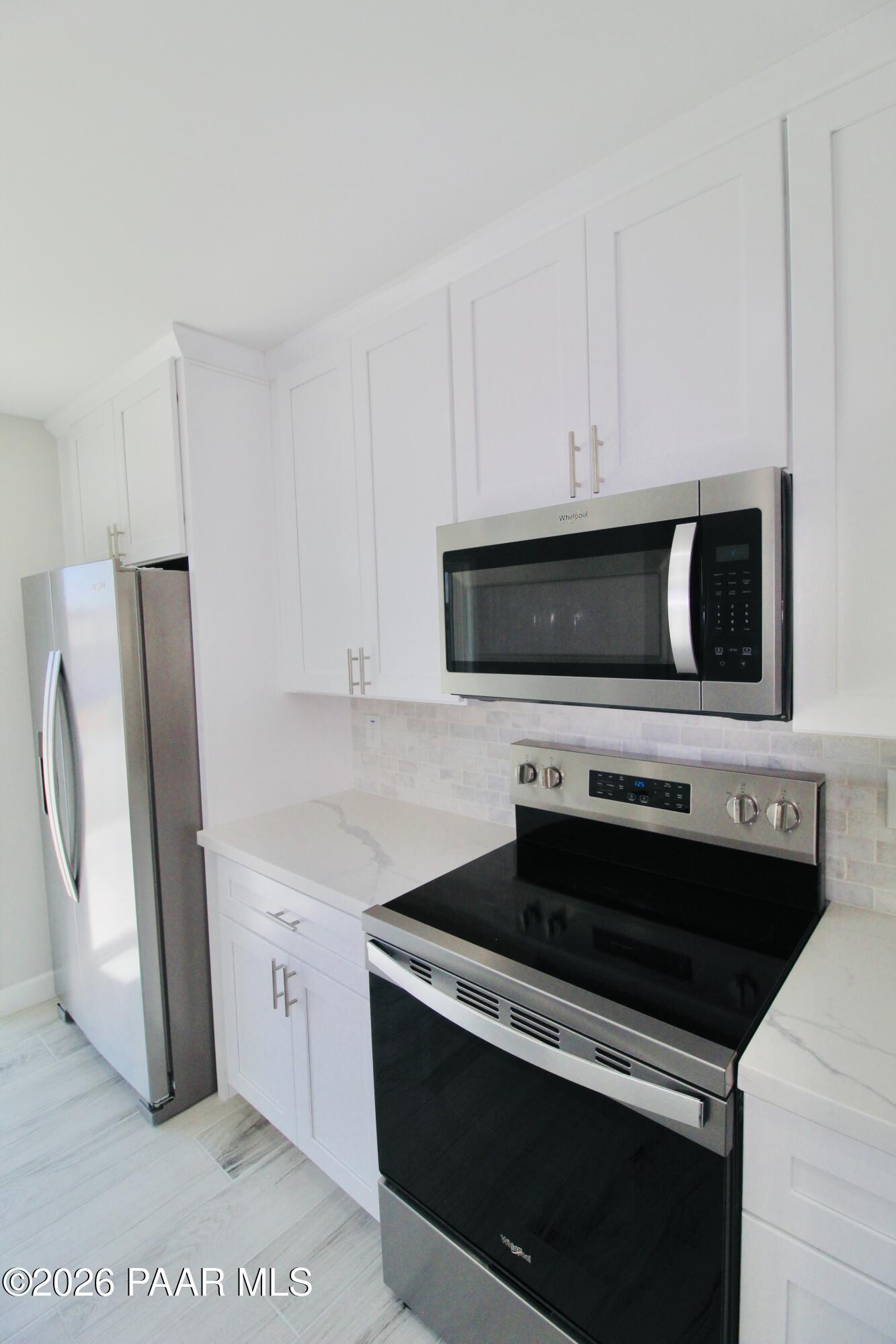20275 East Mesa Verde Road Mayer, AZ 86333 - Photo 7 of 34 a kitchen with stainless steel appliances a stove a microwave and a refrigerator