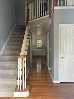a view of a hallway with wooden floor and staircase