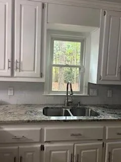 a kitchen with granite countertop a sink and a window
