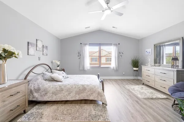 a view of a hallway with wooden floor and a bedroom