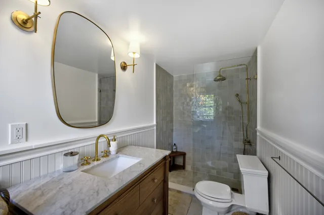 a bathroom with a granite countertop sink toilet and shower