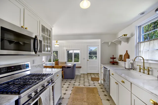 a kitchen with stainless steel appliances a stove sink microwave and cabinets