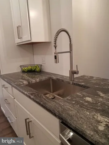 a kitchen with granite countertop a sink and a stove