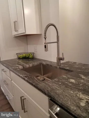 a kitchen with granite countertop a sink and a stove