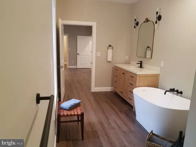 a bathroom with a tub sink and mirror