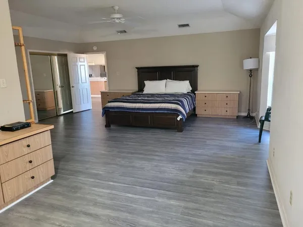 a bedroom with a bed and a mirror on the dresser