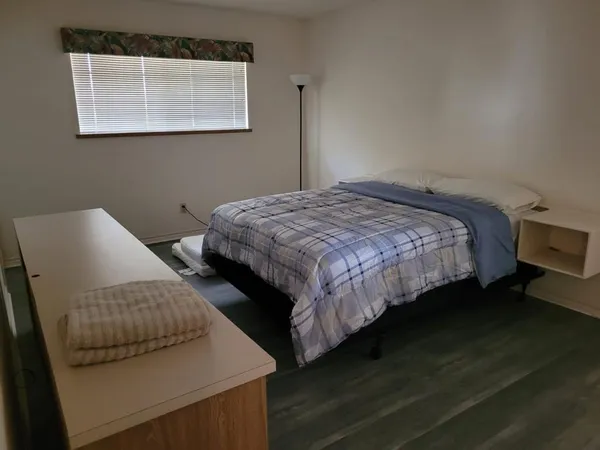 a bedroom with a bed and wooden floor