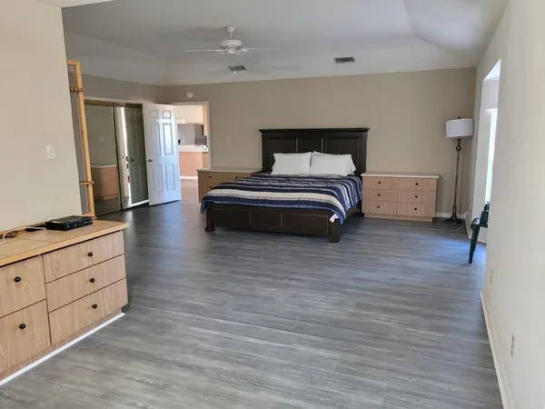 a bedroom with a bed and wooden floor