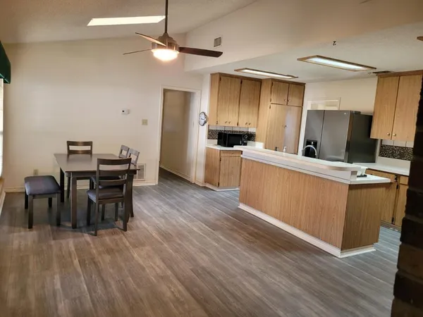 a kitchen with a table chairs refrigerator and cabinets