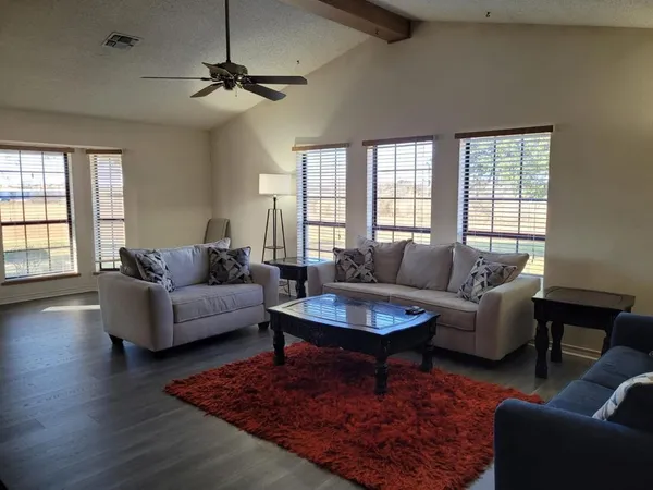 a living room with furniture a rug and a chandelier