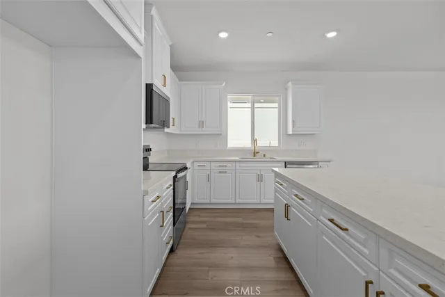 a kitchen with granite countertop white cabinets and white appliances