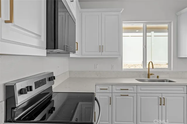 a kitchen with stainless steel appliances granite countertop a sink and a stove