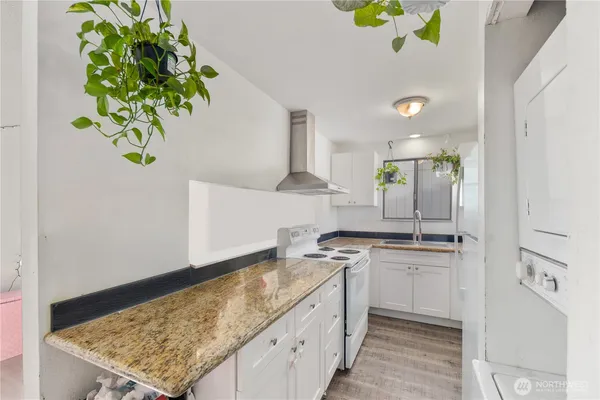 a kitchen with kitchen island granite countertop stainless steel appliances sink stove and cabinets