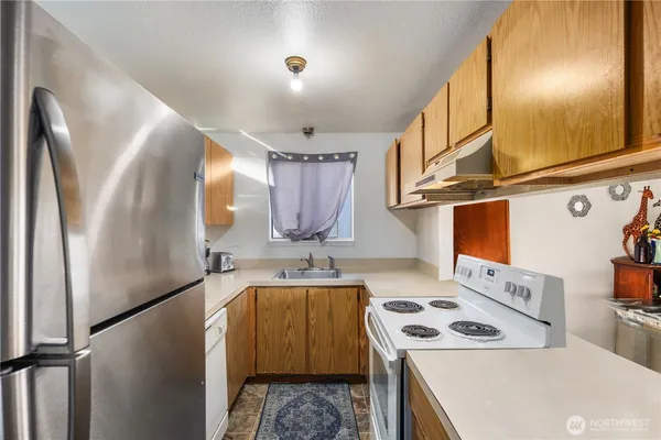 a kitchen with stainless steel appliances granite countertop a sink a stove and a refrigerator