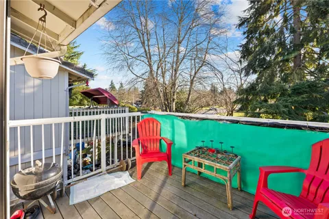 a view of a deck with wooden chairs and iron fence
