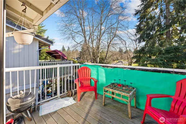 a view of a deck with wooden chairs and iron fence