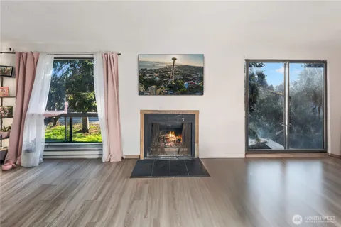 a view of a livingroom with wooden floor and a fireplace