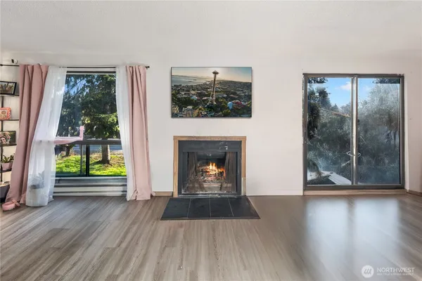 a view of a livingroom with wooden floor and a fireplace