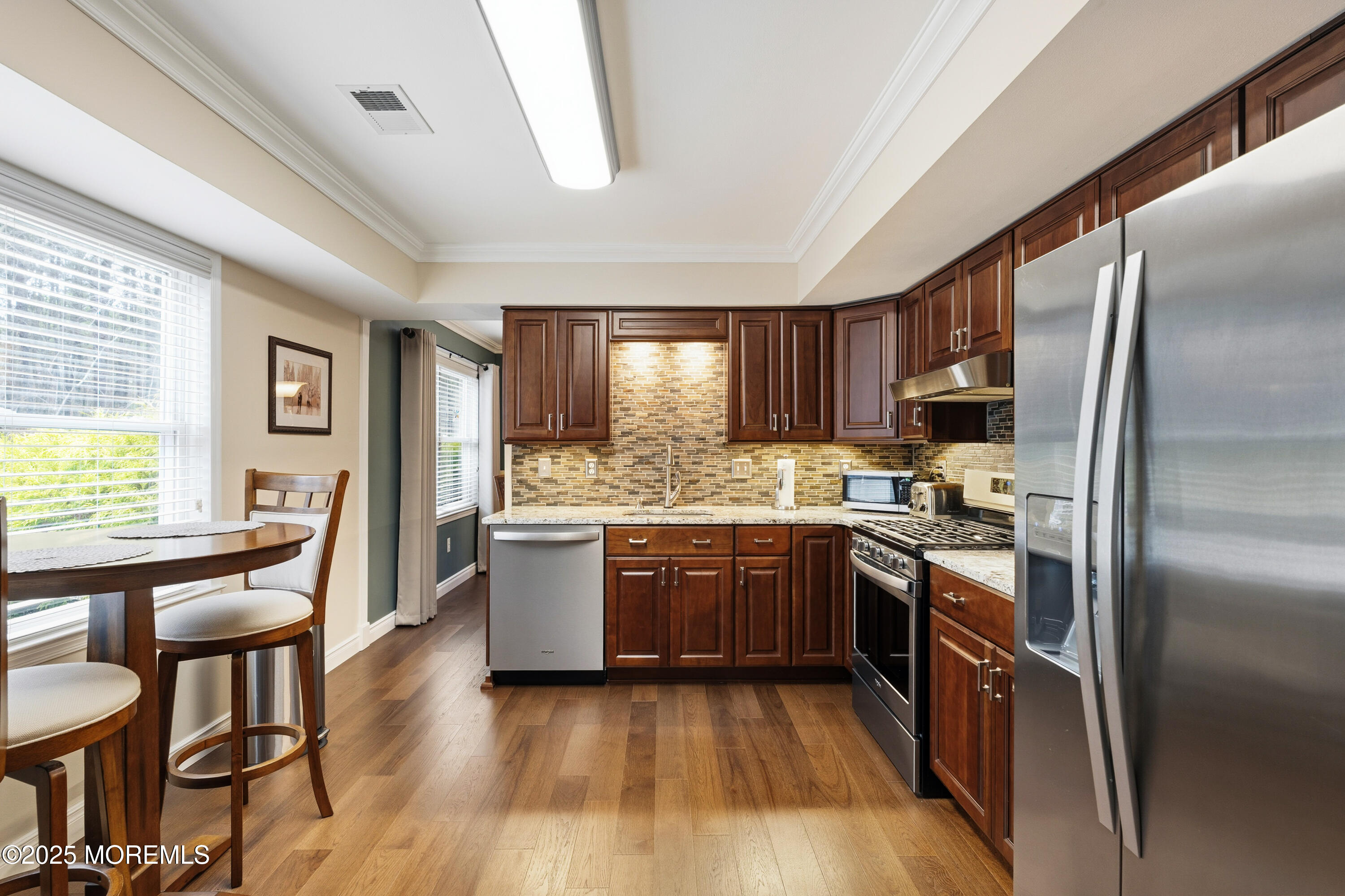 262 Frank Applegate Road Jackson, NJ 08527 - Photo 13 of 37 a kitchen with stainless steel appliances granite countertop a refrigerator a stove a sink dishwasher a dining table and chairs with wooden floor