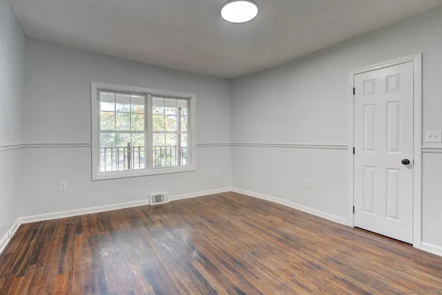 wooden floor in an empty room with a window