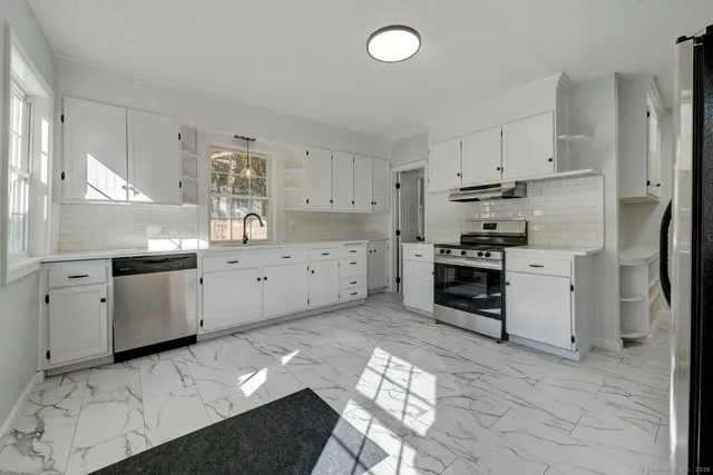 a kitchen with white cabinets and appliances