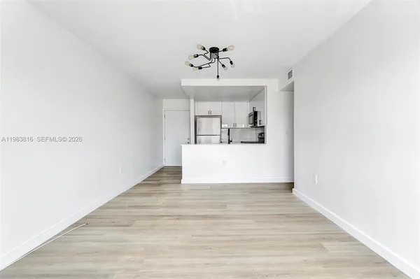 a view of a kitchen with wooden floor and ceiling fan