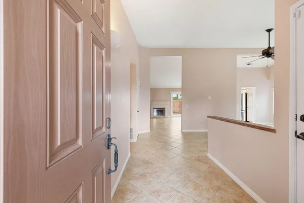 a view of a hallway with white walls and wooden floor