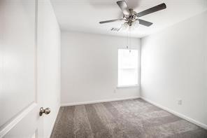 195 Cherry Tree Livingston, TX 77351 - Photo 5 of 8 an empty room with a chandelier fan and windows