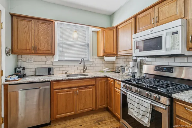 a kitchen with stainless steel appliances granite countertop a sink stove and cabinets