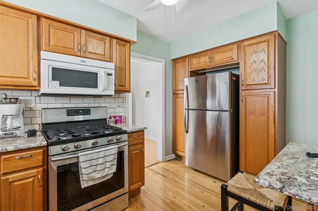 a kitchen with granite countertop a refrigerator and a stove top oven