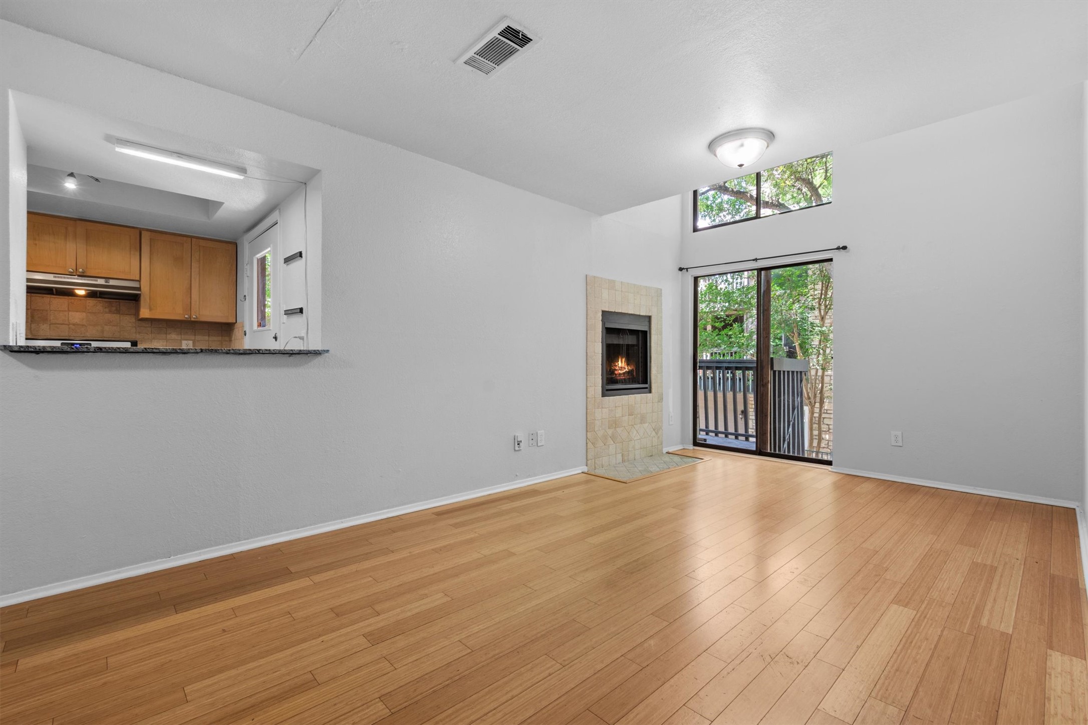 3627 Menchaca Road, Unit 204 Austin, TX 78704 - Photo 2 of 23 A vibrant living area with gleaming wood flooring, a modern fireplace, and a private balcony.