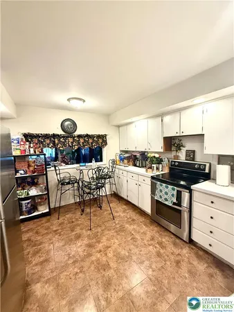 a kitchen with stainless steel appliances kitchen island granite countertop a stove and a refrigerator