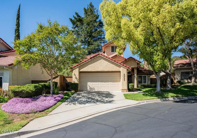 a front view of a house with yard and green space