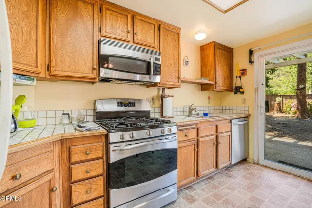a kitchen with stainless steel appliances granite countertop a stove a sink and a microwave
