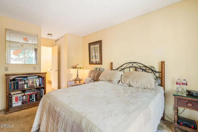a bedroom with a large bed and a book shelf
