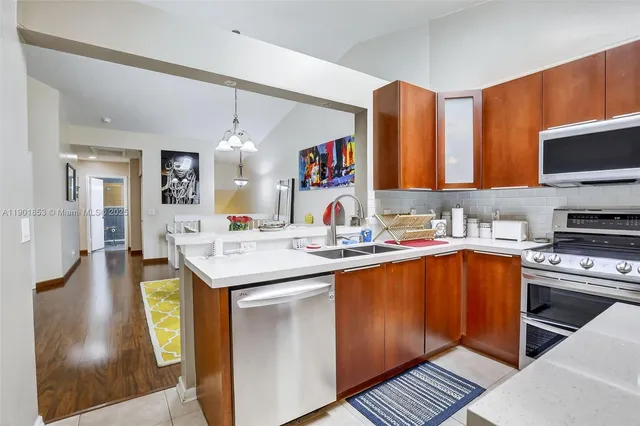 a kitchen with a sink and a stove top oven with wooden floor