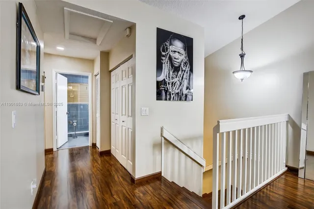 a view of a hallway with wooden floor and stairs