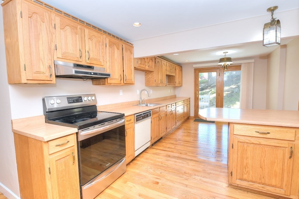 165 R Green Street Stoneham, MA 02180 - Photo 11 of 42 a kitchen with stainless steel appliances a stove sink and cabinets