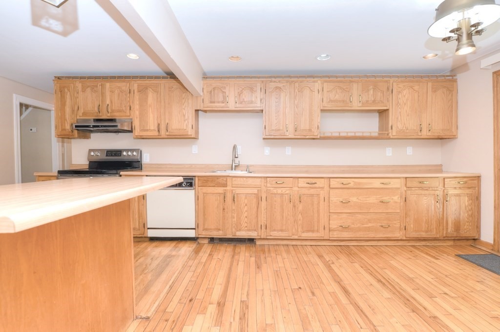 165 R Green Street Stoneham, MA 02180 - Photo 9 of 42 a large kitchen with stainless steel appliances wooden floors and view living room