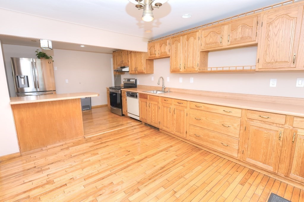165 R Green Street Stoneham, MA 02180 - Photo 10 of 42 a large kitchen with cabinets and wooden floor