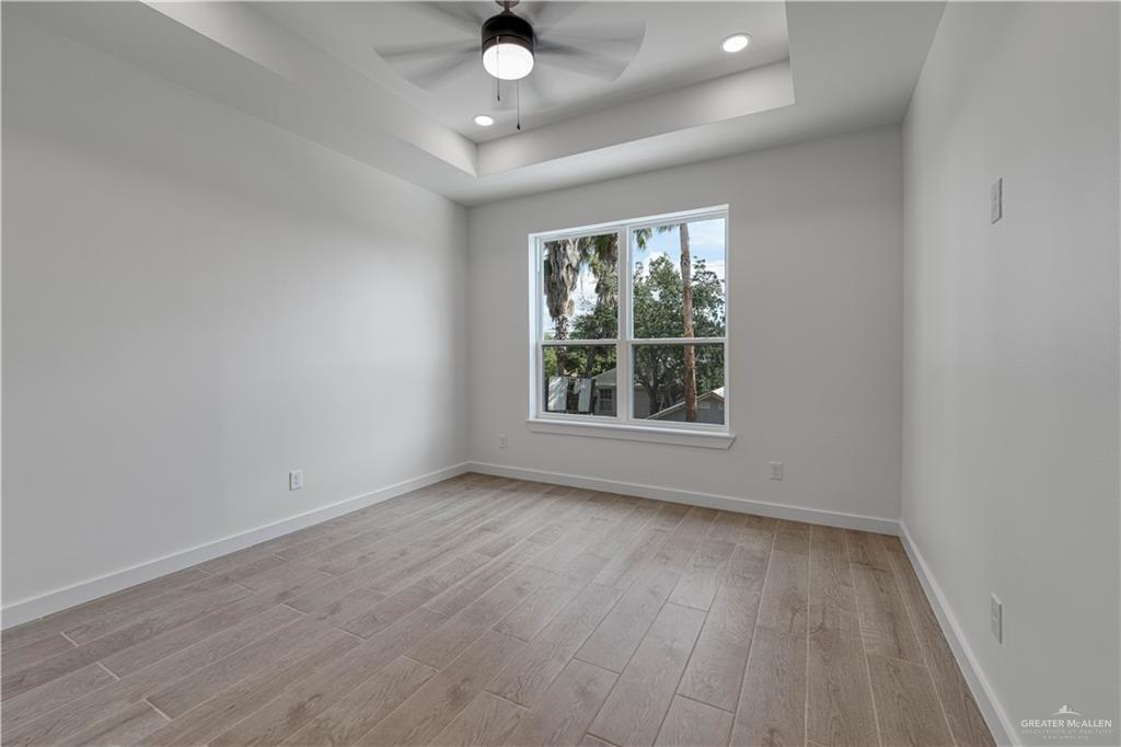 5408 North Crown Point Pharr, TX 78577 - Photo 11 of 19 an empty room with wooden floor and windows